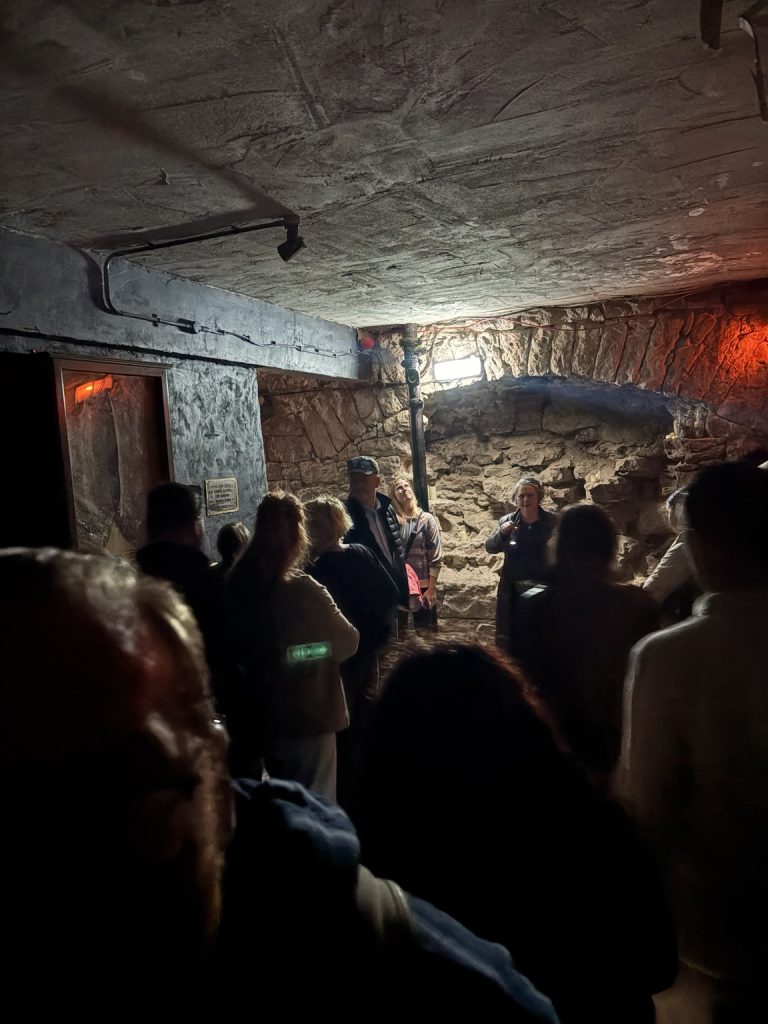 A tour group gathered around a guide inside Edinburgh’s South Bridge vaults.