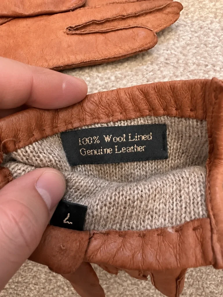 Inside cuff label reading 100% Wool Lined and Genuine Leather beside a size L label